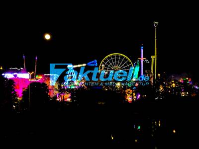 Stuttgarter Frühlingsfest bei Nacht mit dem Vollmond im Hintergrund