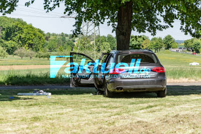 Heldenhaft: Ersthelfer schlägt mit Leitpfosten Scheibe ein und befreit schwer verletzten Fahrer, nachdem dieser mittig über Kreisverkehr schanzte und frontal in Baum krachte - Rettungshubschrauber fliegt schwer Verletzten ins Krankenhaus