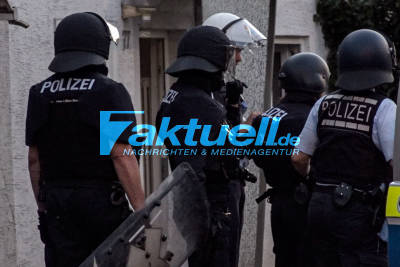 Mann klettert auf Hausdach und bewirft Polizisten mit Ziegel und Fenstern und droht 