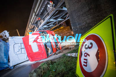 1:0 für Stahlkoloss: Sattelzug kracht gegen Bahnbrücke und kippt um, Insassen schwer verletzt:  Ersthelfer klettert ins Wrack - Aufwendige Bergung fordert Einsatzkräfte