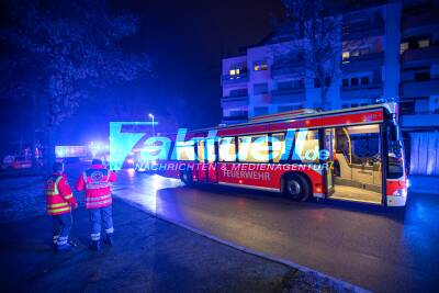 Eine Tote und über ein Dutzend Verletzte bei Wohnungsbrand: Feuer verursacht Großeinsatz in Mehrfamilienhaus - Rettungsbus versorgt Bewohner