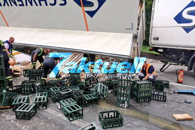 Tausende Flaschen flüssiges Obst landen auf Fahrbahn: Langer Stau bis auf die Autobahn zurück - Getränkelaster kippt um 