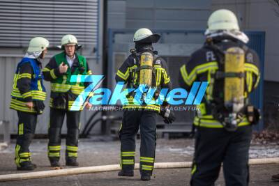 Feuerwehr löscht brennende Maschine einer Druckerei