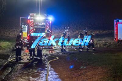 Strohballen brennen auf Traktor unter Scheunendach
